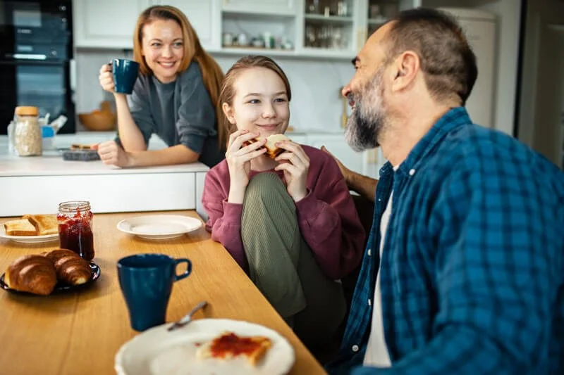 parents eating and talking with teenage daughter
