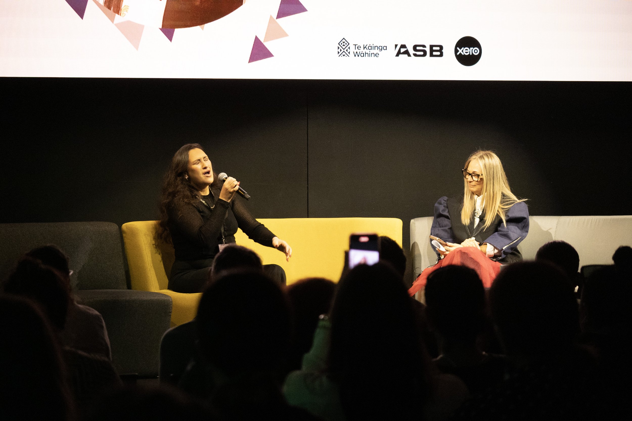 Hamo Dell signing on stage at Te Mana o ngā Wāhine