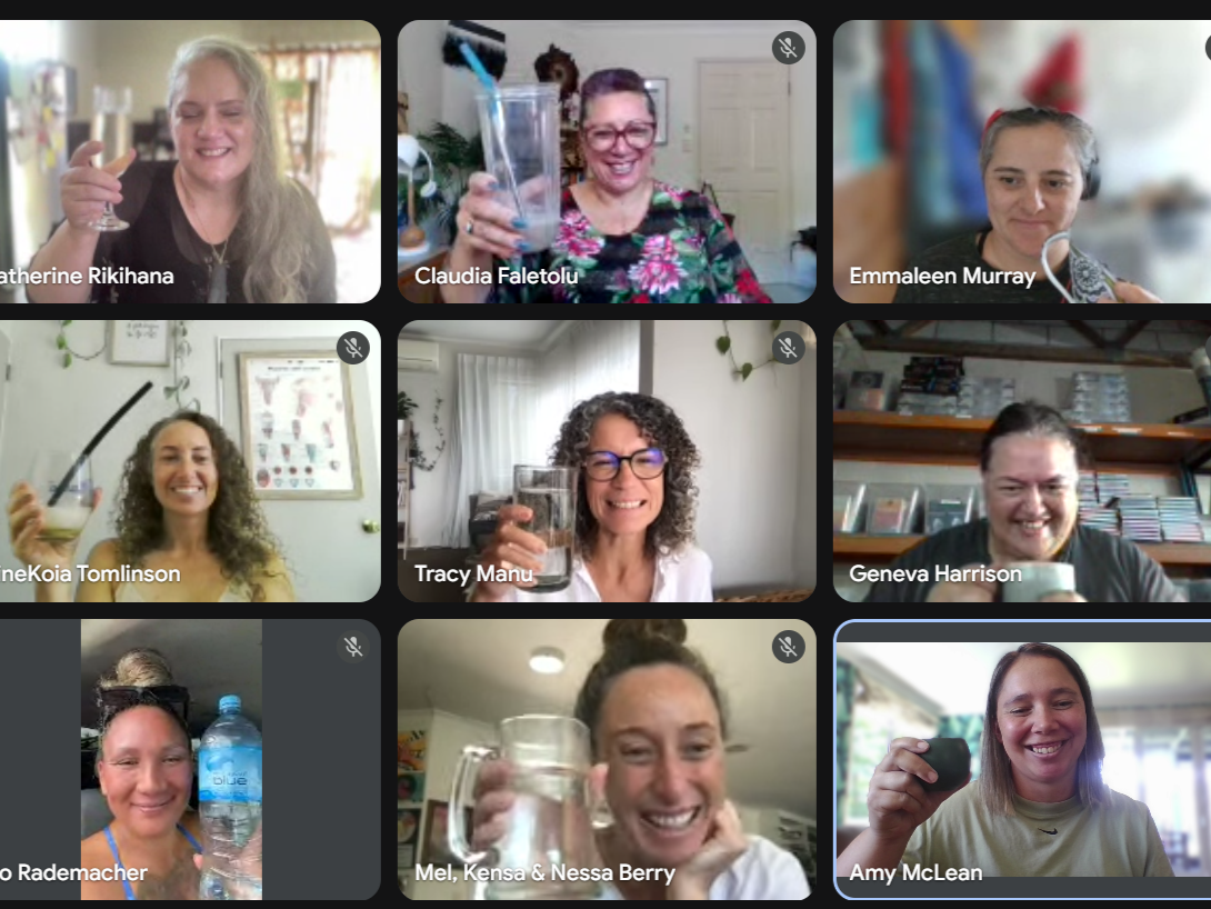 An online kōrero group of nine wāhine, each holding a glass of water or a beverage, smiling and celebrating together.