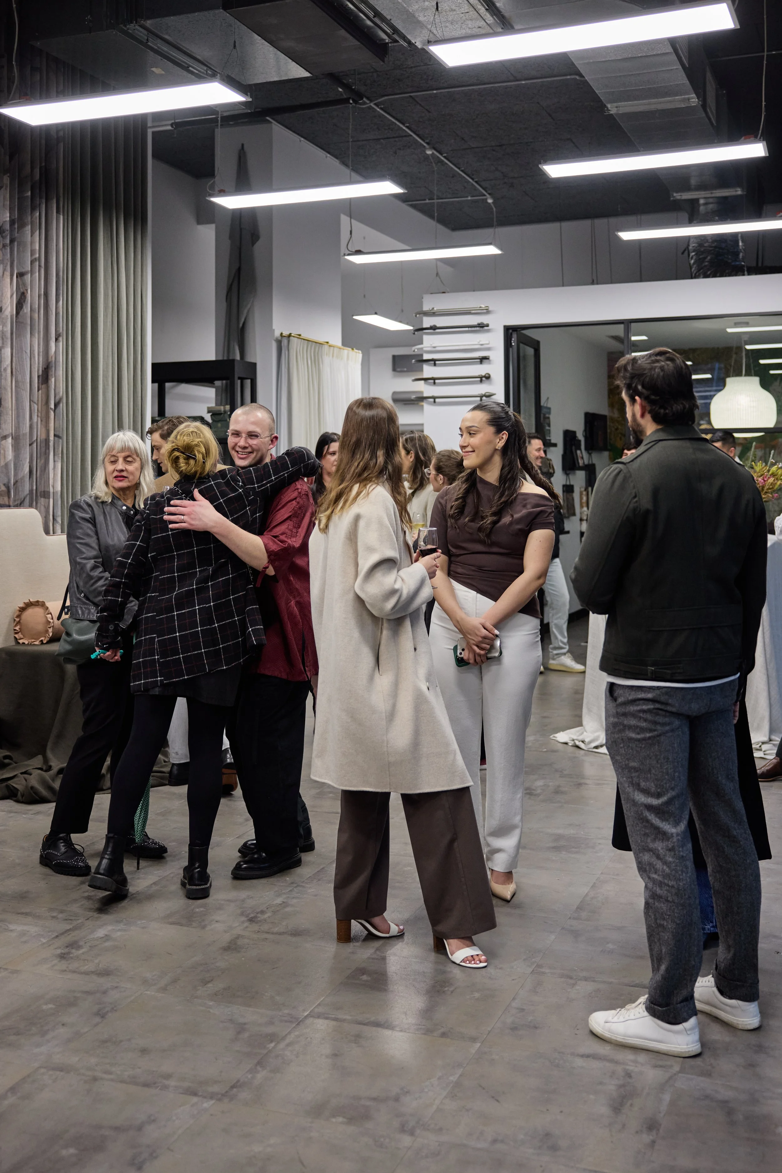 People socializing at a party in an indoor space with modern decor and artwork on the walls.