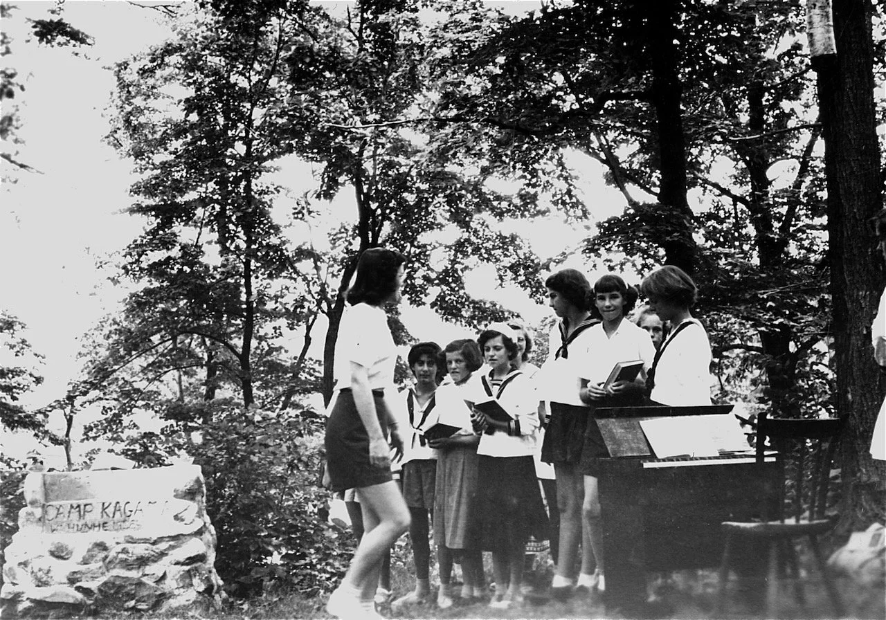 Vesper Point at Sheik's Island. You can see the original altar and the prairie organ used for music. The camper second form the right behind the organ with a book in her hands, is Joan (MacLeod) McEwan.