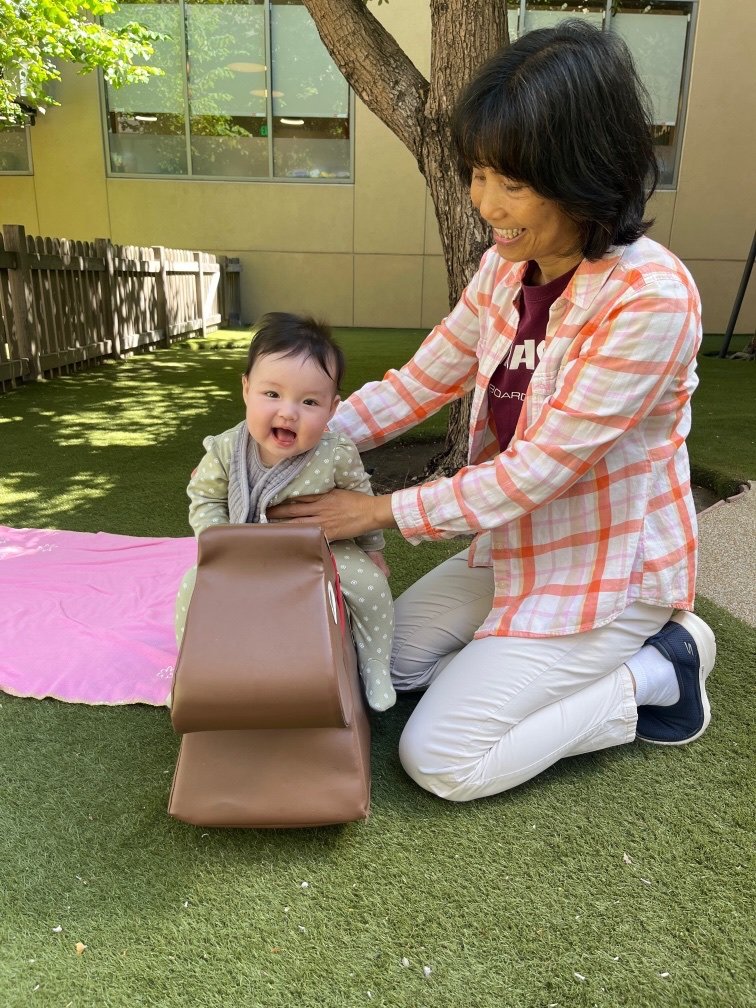 baby and preschool teacher smiling and having fun