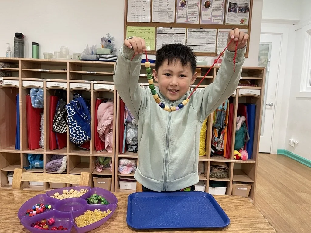 boy holding a necklace he created