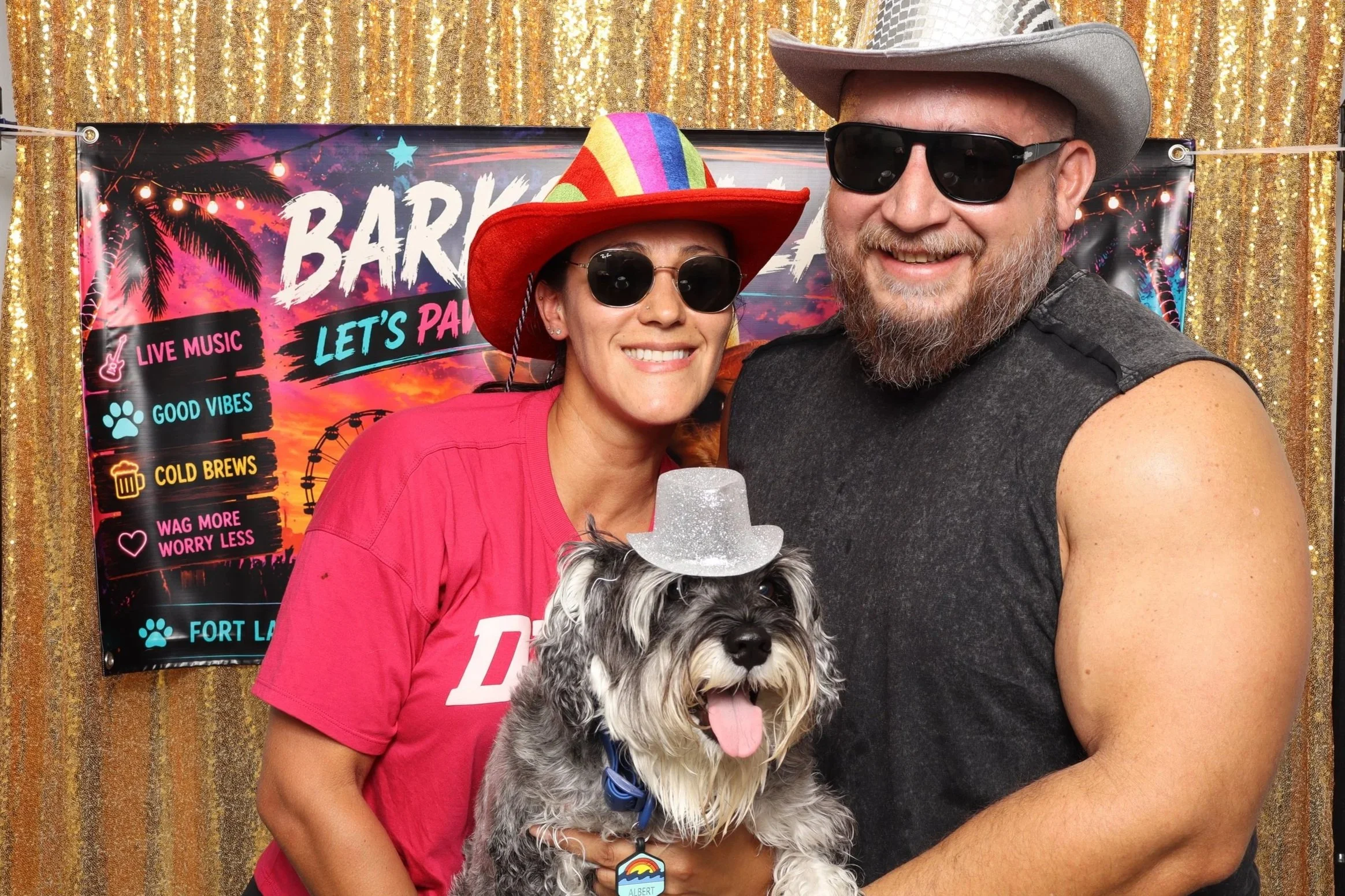 Couple and a dog in sunglasses posing with "Let's Party" props at a custom photo booth backdrop at photo booth rental in Fort Lauderdale, FL - D&amp;L Photobooths 
