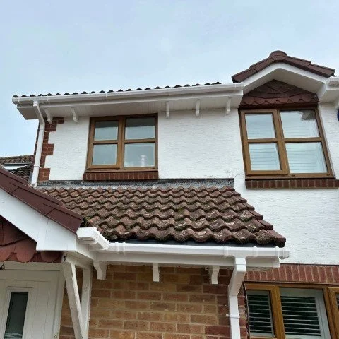 Image showing front of detached property in Broadstone, Poole with new white UPVC Fascias, white UPVC tongue and grove Soffits and white square UPVC guttering