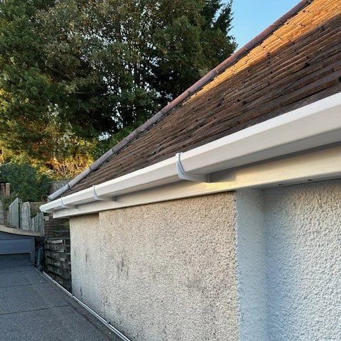 side view of the bungalow showing newly fitted white square guttering
