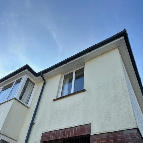 front corner of a detached property showing new fascias and soffits in white upvc