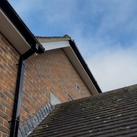 rear side of detached property in Wimborne Dorset with replacement white UPVC fascias, white UPVC soffits and white UPVC bargeboards and new black square UPVC guttering and downpipes
