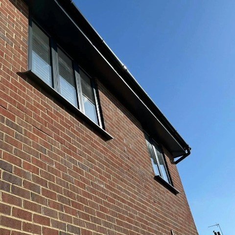 Image showing the rear of a detached property in Poole with new anthracite grey UPVC fascias and soffits and black half round guttering