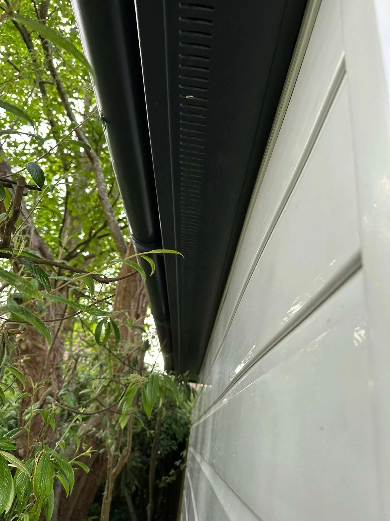 anthracite grey vented soffits against white shiplap UPVC.jpg