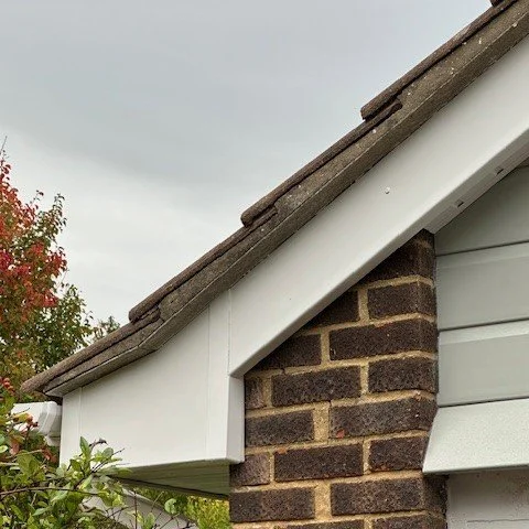 close up of the front corner of the bungalow fitted with new white upvc bargeboards and agate grey cladding