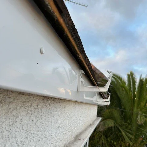 close up image of white guttering being fitted with a stringline
