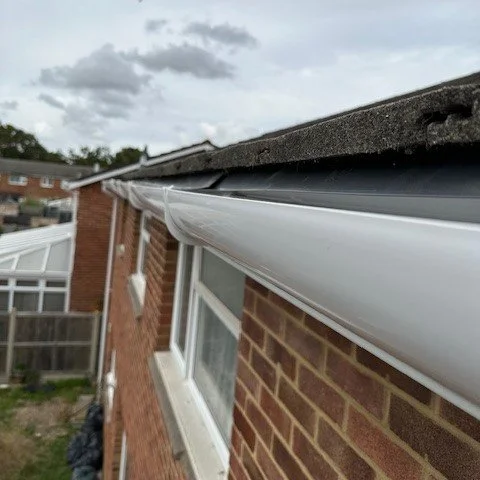 close up image of white deep flow guttering fitted to a house