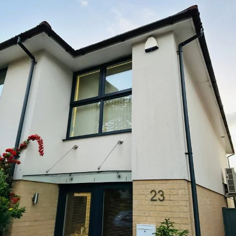 Showing the front of a Poole detached property with UPVC black round guttering and black round downpipes replacement