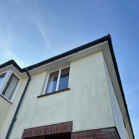 corner of the property showing white soffits and fascias with black round guttering
