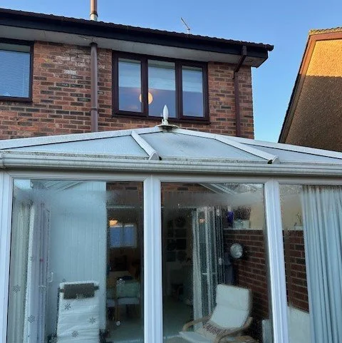 Back of a detached property in Wallisdown Poole showing conservatory before UPVC fascias and guttering replacment