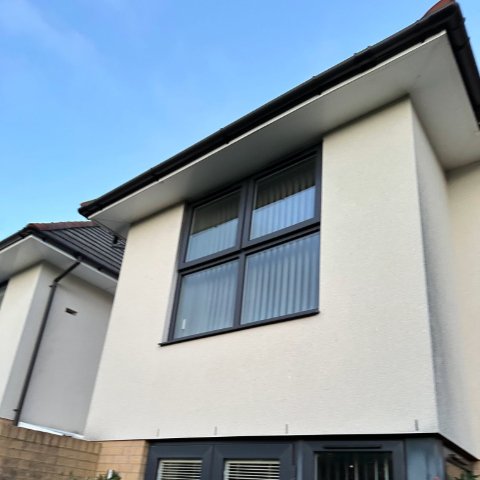 Back of Poole detached property with UPVC black round guttering after roofline replacement