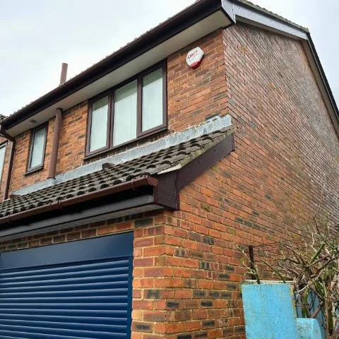 Side and front of detached property in Poole after Rosewood UPVC fascias and bargeboards and white UPVC tongue and groove soffits and brown square guttering replacement 