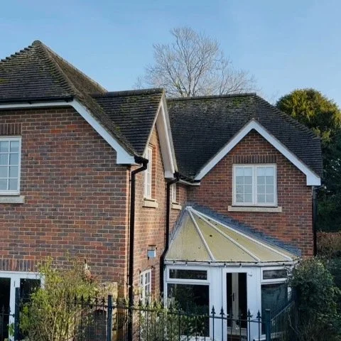 rear of detached property in Wimborne Dorset with replacement white UPVC fascias, white UPVC soffits and white UPVC bargeboards and new black square UPVC guttering and downpipes