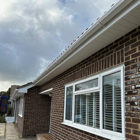 side view of a brick built bungalow with new white fascias and soffits with white square guttering