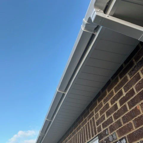view from underneath of new white tongue and goove soffits and white square guttering with down pipe