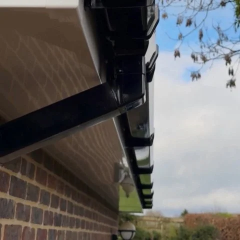 Image shows close up of replacement white UPVC fascias, white UPVC soffits and new black square UPVC guttering in Wimborne Dorset