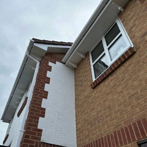 Image showing front of detached property in Broadstone, Poole with new white UPVC Fascias, white UPVC tongue and grove Soffits and white square UPVC guttering