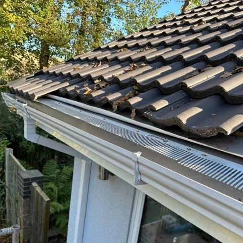 Image shows metal birdcomb bird guard system being installed under tiles in Christchurch, Dorset
