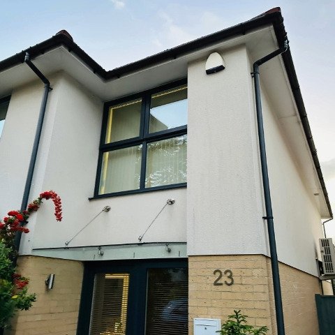 Image shows new black UPVC guttering and black UPVC downpipe replacement on the front of a detached property in Poole, Dorset after guttering repair