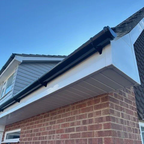 front corner section of the bungalow showing new white fascia and soffits with new black round guttering