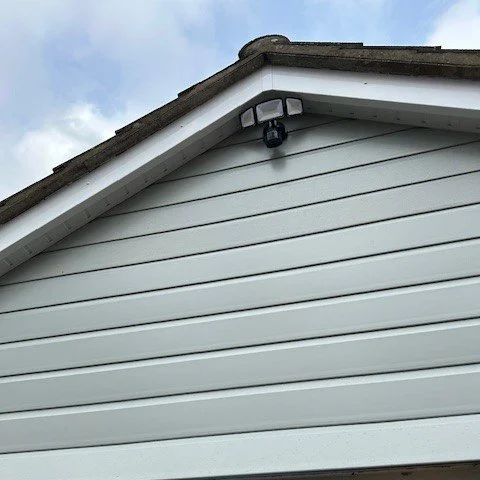 close up of the front of the garage fitted with new agate grey cladding and white bargeboards.