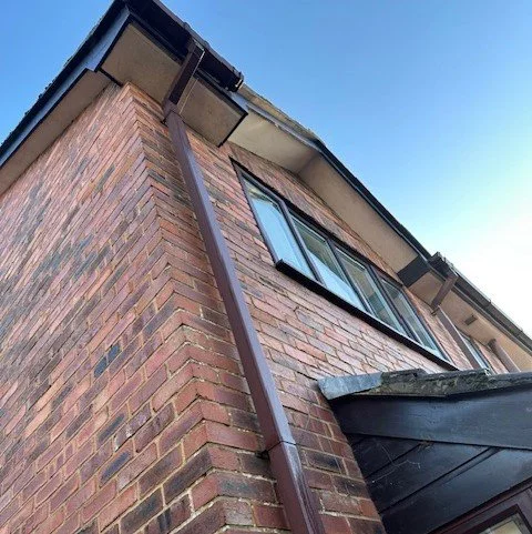 Side of detached house in Poole before fascias and soffits replacement