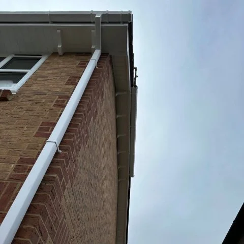 Image from below of detached property in Broadstone, Poole with new white UPVC Fascias, white UPVC tongue and grove Soffits and white square UPVC guttering