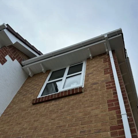 image from below of white UPVC fascias and soffits on roofline in Poole
