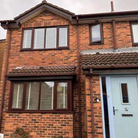 Image shows the front of a detached property in Wallisdown, Poole, with new Rosewood UPVC fascias, white UPVC tongue and groove soffits and brown square UPVC guttering