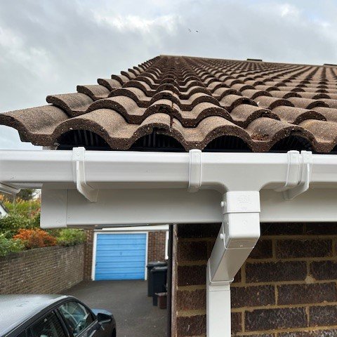 close up of white square guttering fitted to new white fascias 