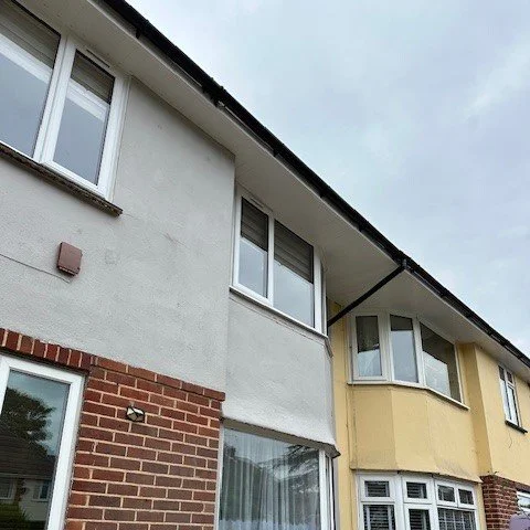 exterior image of a 3 bed house newly painted in grey sandtex paint and white fascias and soffits fitted with black round guttering