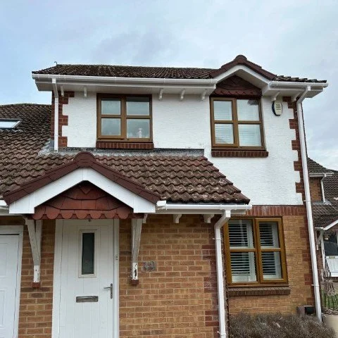 Image showing front of detached property in Broadstone, Poole with new white UPVC Fascias, white UPVC tongue and grove Soffits and white square UPVC guttering