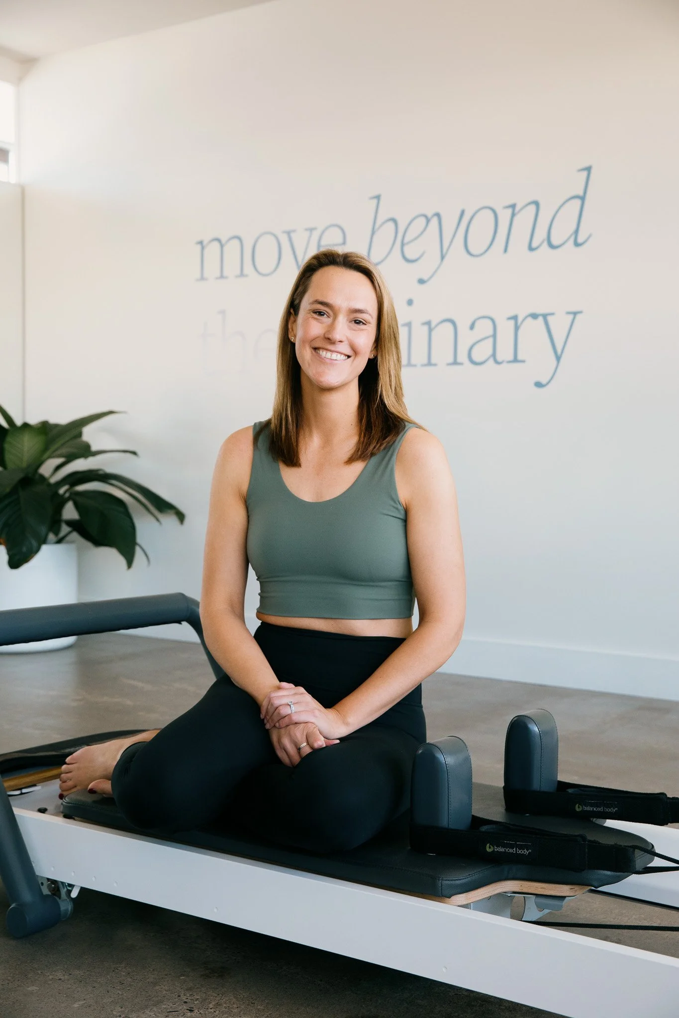 Studio owner, Alicia sitting on a Pilates reformer in Salt Pilates Studio in Balaclava.
