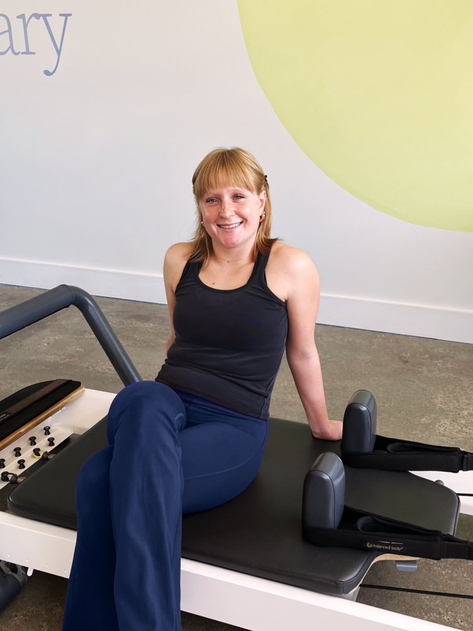 Salt Pilates instructor, Pascale, sitting on reformer in the Salt Pilates Studio in Balaclava.