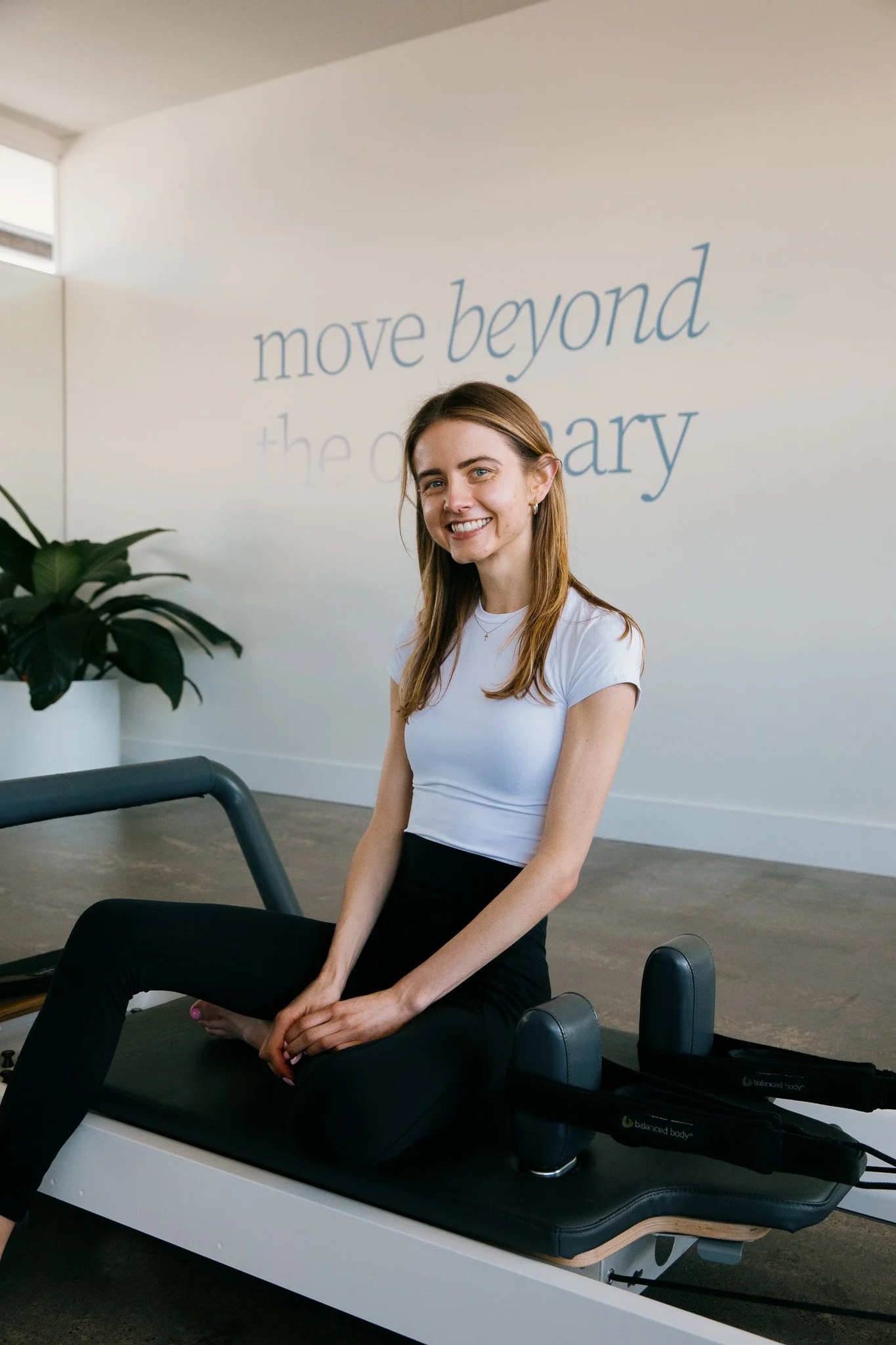 Salt Pilates instructor, Tash, sitting on reformer in the Salt Pilates Studio in Balaclava.