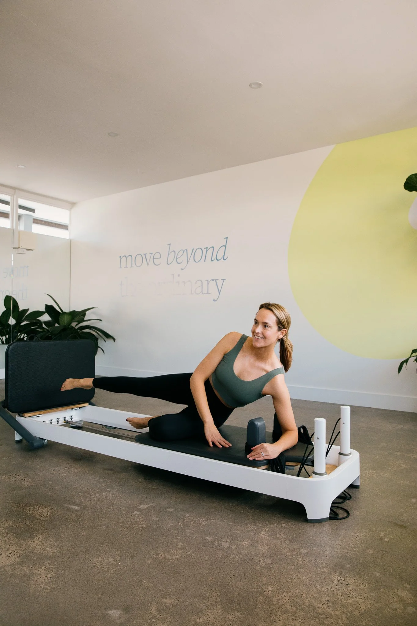 A modern building with wooden vertical slats on the front and a large glass window, set against a backdrop of mountainous landscape with dry grass and sparse trees.