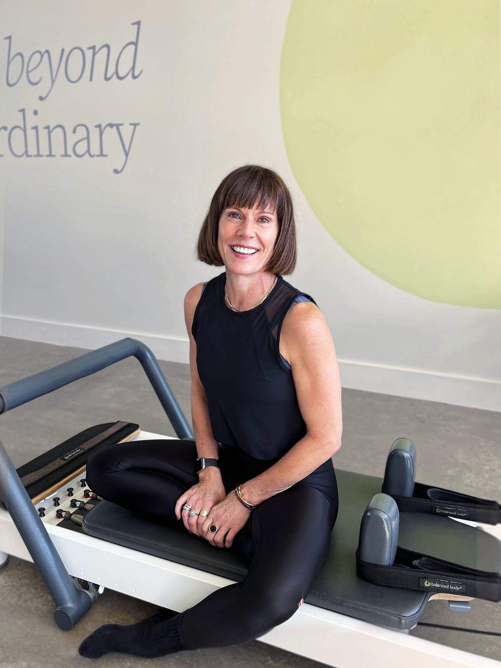 Salt Pilates instructor, Samm, sitting on reformer in the Salt Pilates Studio in Balaclava.