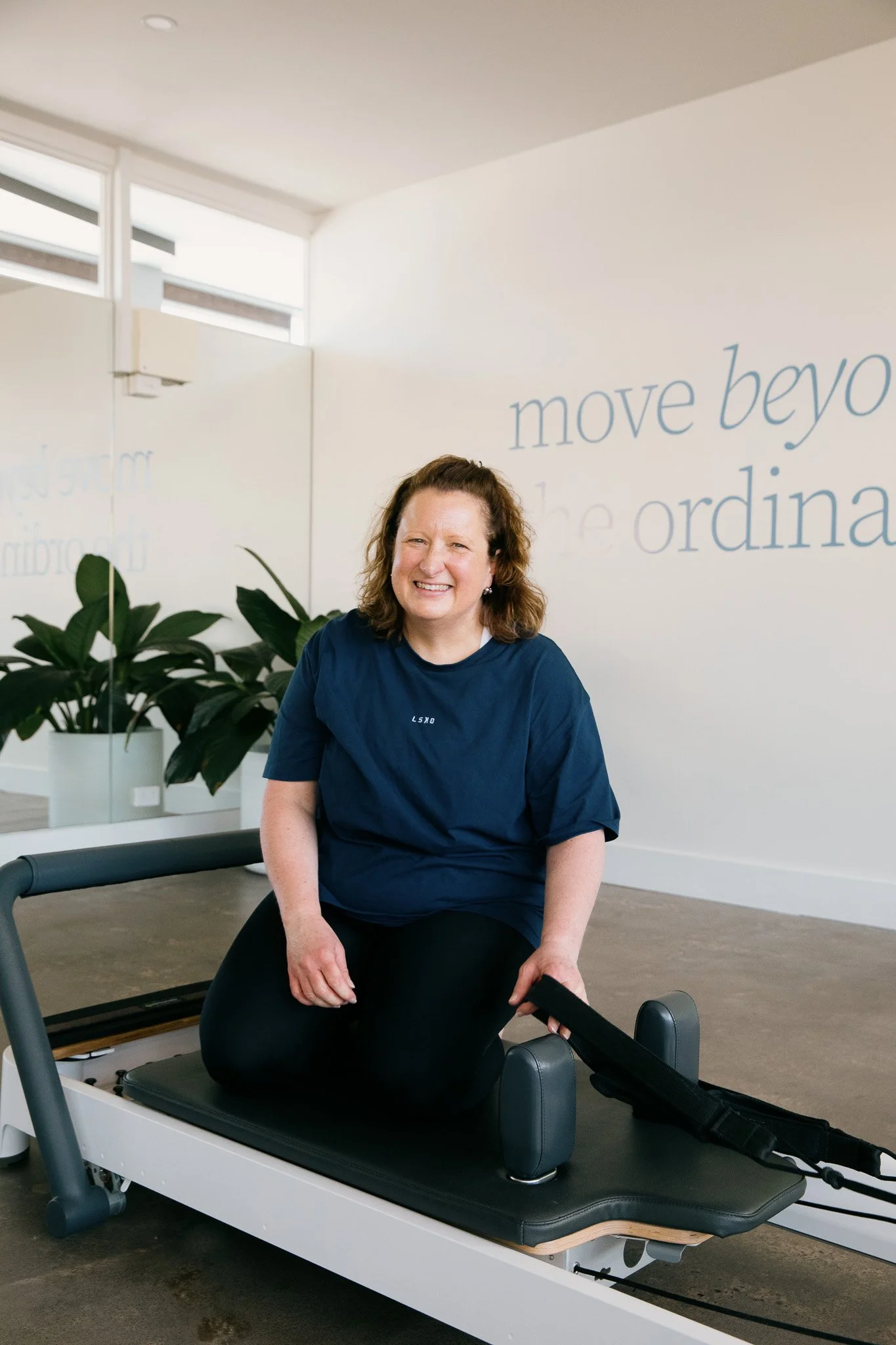 Salt Pilates instructor, Sarah, sitting on reformer in the Salt Pilates Studio in Balaclava.