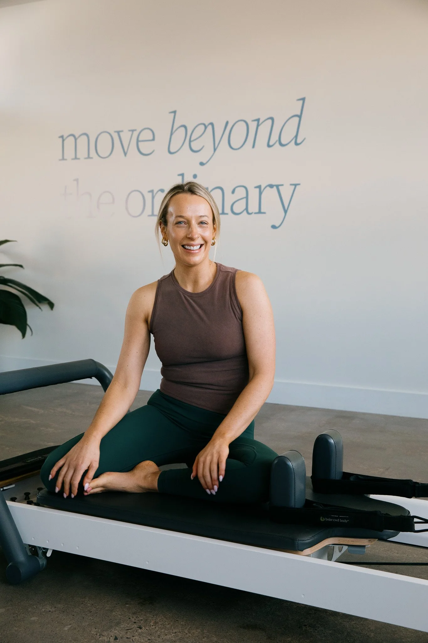 Salt Pilates instructor, Tess, sitting on reformer in the Salt Pilates Studio in Balaclava.