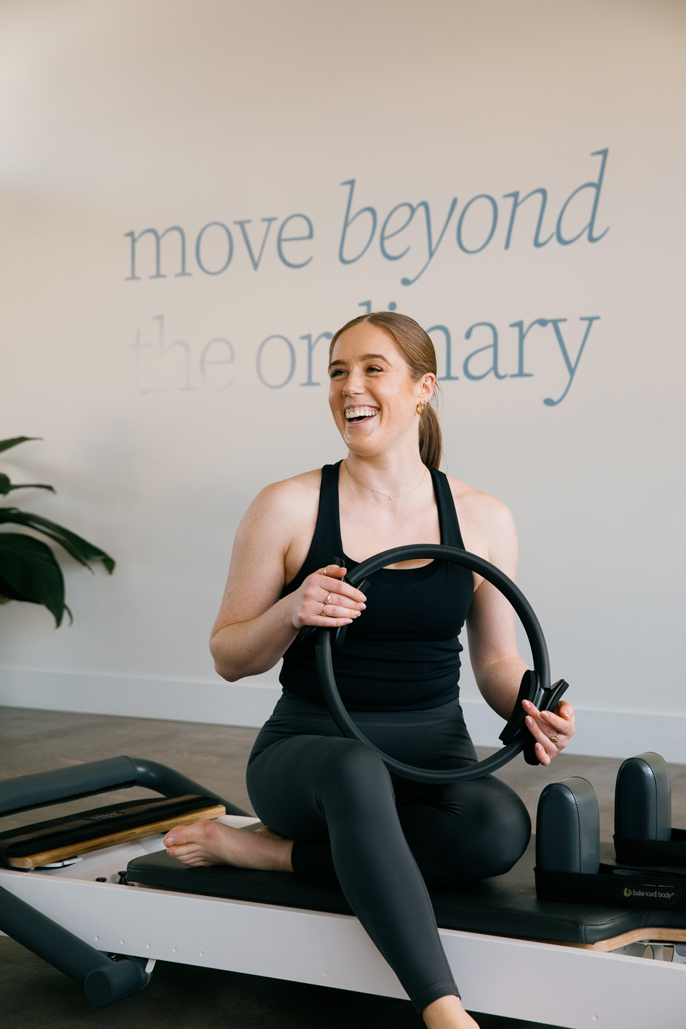 Salt Pilates instructor, Ashleigh, sitting on reformer in the Salt Pilates Studio in Balaclava.