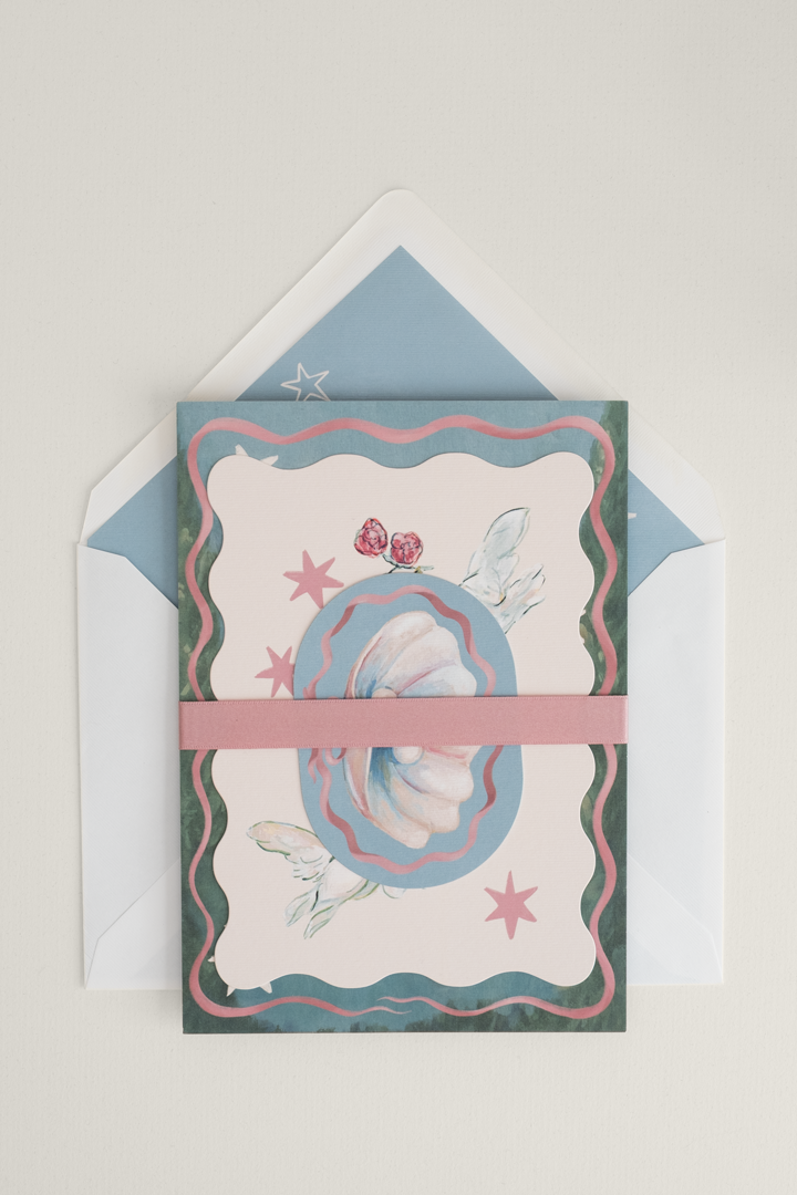 Fairytale Coquette wedding invitation suite stacked and finished with a soft rose satin ribbon band, layered over a romantic illustrated envelope liner.