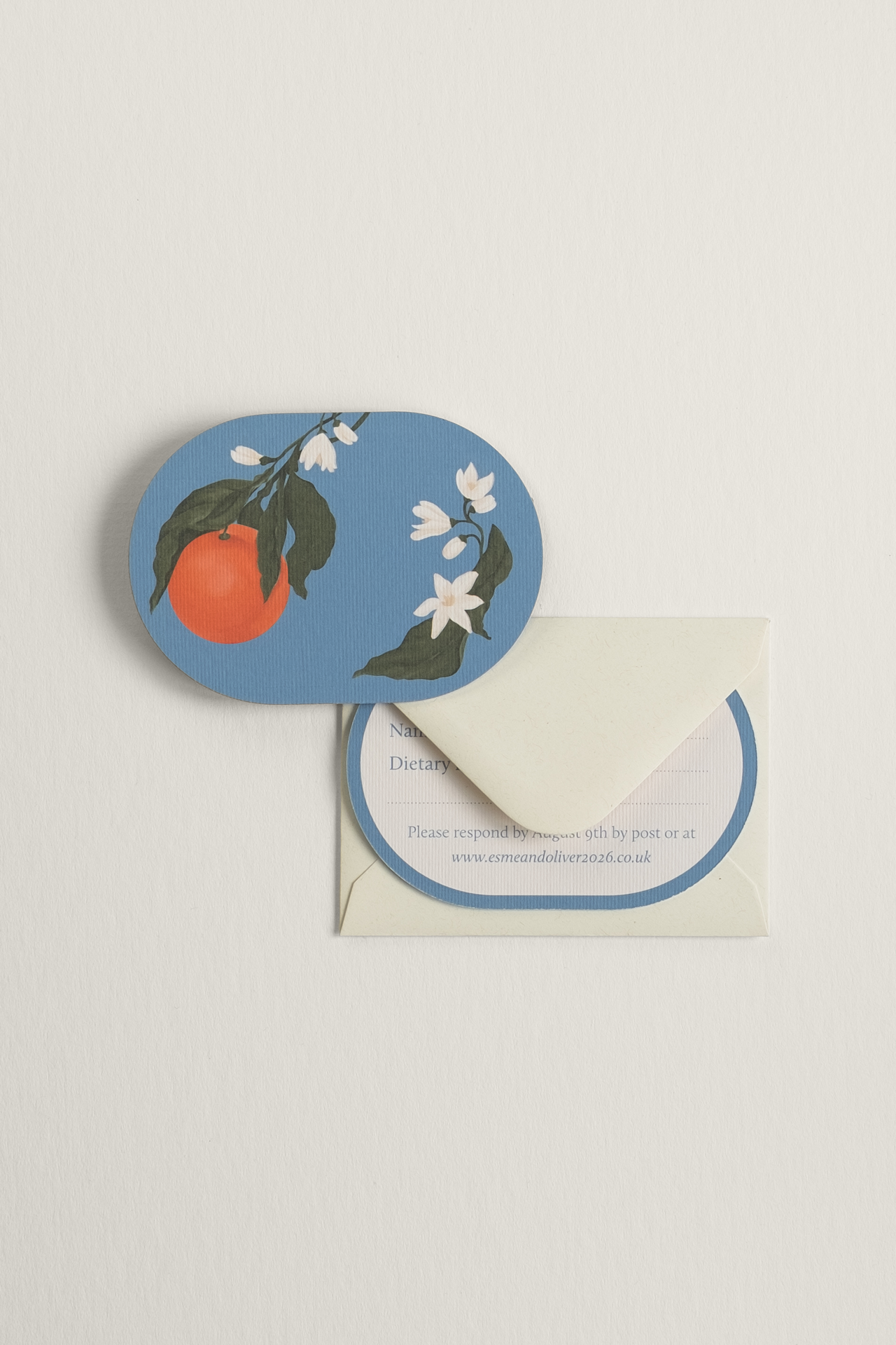 Orangery wedding RSVP card front displayed next to a flecked cream envelope, with the guest response reverse side tucked within the  envelope flap.