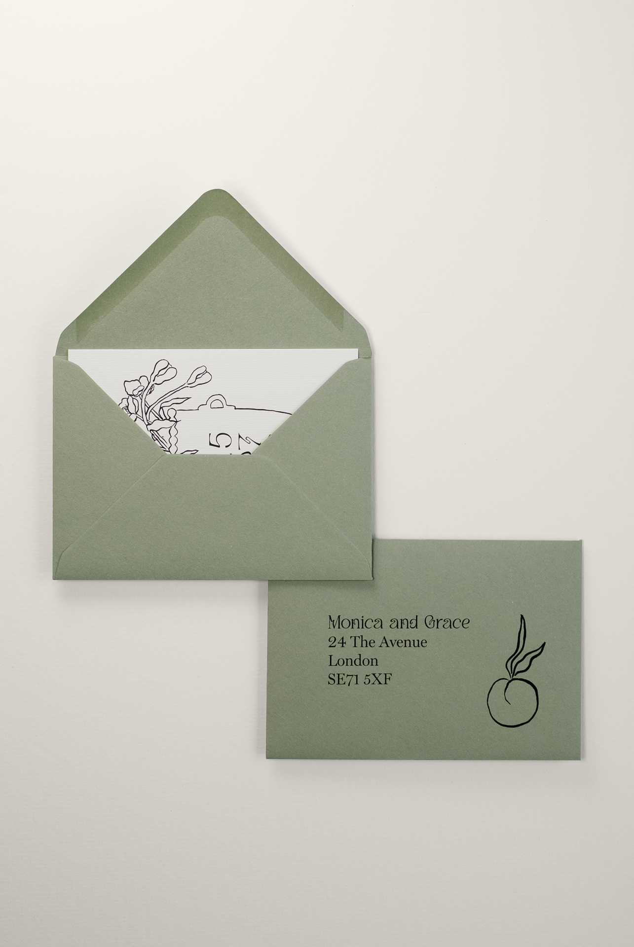Pale green wedding envelope featuring professional guest addressing, with a Tulips collection Save the Date card tucked inside to reveal the artistic black ink illustration.