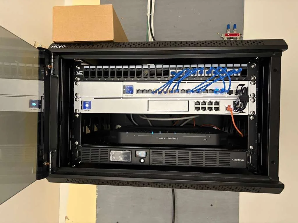 Server rack with network equipment, switches, and a CyberPower UPS.